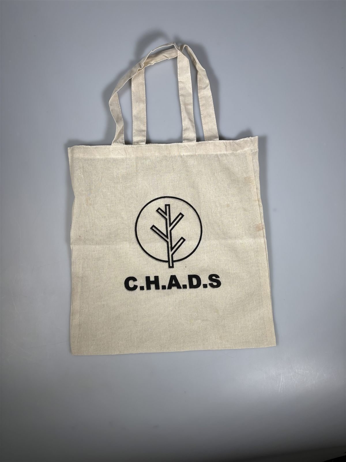 C.H.A.D.S logo screen-printed on a natural canvas tote bag