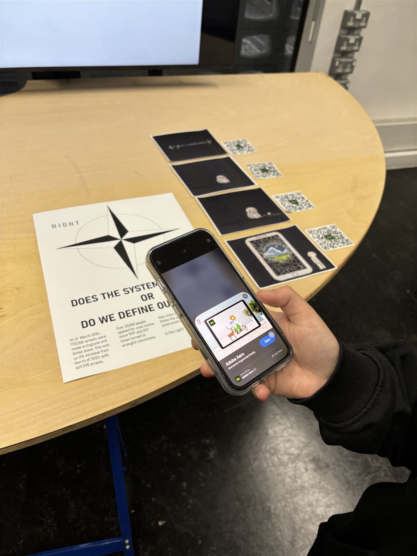 Visitor holding a phone over the poster, AR scale rendered on screen
