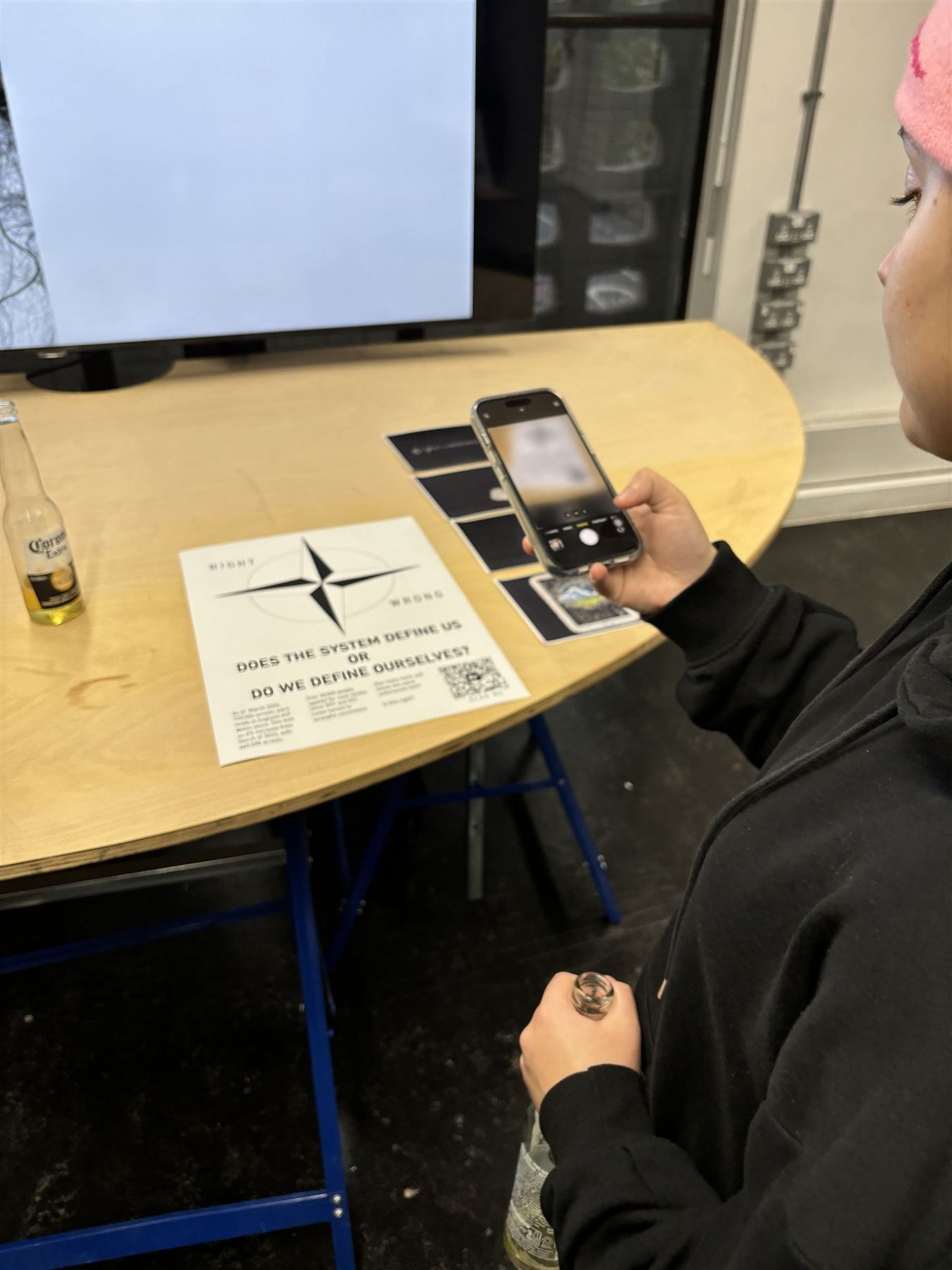 Exhibition view of the poster with a visitor scanning the QR code